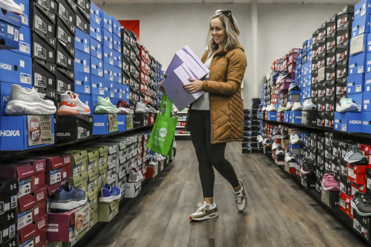 FILE - Ashley Crafton looks at tennis shoes at at Shoe Stop while shopping during Small Business Saturday in Wesleyan Park Plaza on Nov. 25, 2023, in Owensboro, Ky.