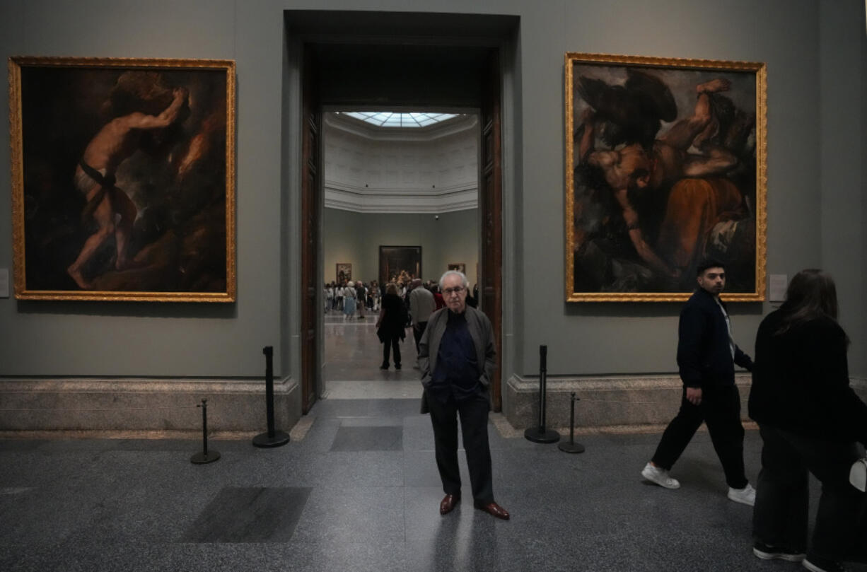 Novelist John Banville poses between Tiziano&rsquo;s &lsquo;Sisyphus&rsquo; on left and Tityus on right on Oct. 23 at the Prado Museum in Madrid, Spain.