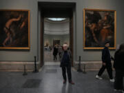 Novelist John Banville poses between Tiziano&rsquo;s &lsquo;Sisyphus&rsquo; on left and Tityus on right on Oct. 23 at the Prado Museum in Madrid, Spain.