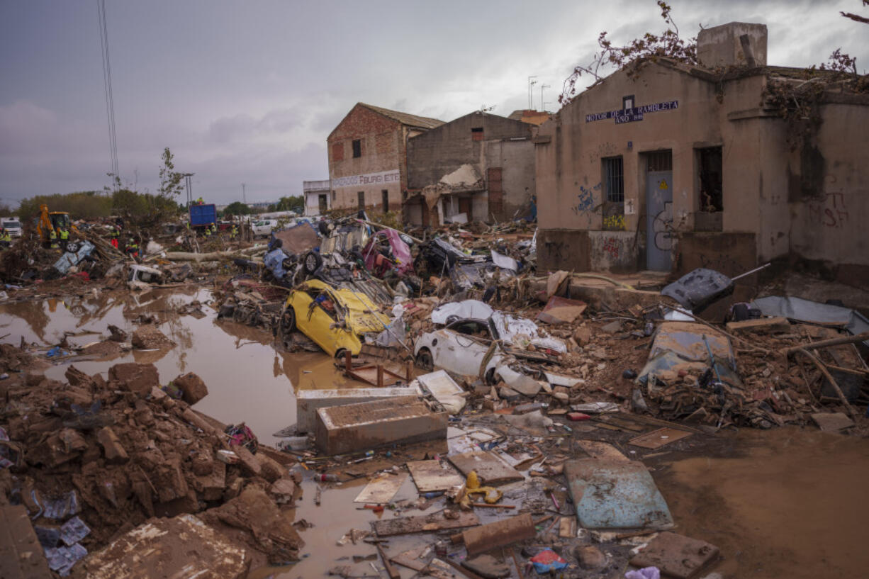 Vehicles remain trapped amid flood debris Sunday in Catarroja, Spain.