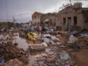 Vehicles remain trapped amid flood debris Sunday in Catarroja, Spain.