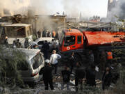 Firefighters and security officers gather at a destroyed building hit in an Israeli airstrike in Damascus, Syria, Thursday, Nov. 14, 2024.