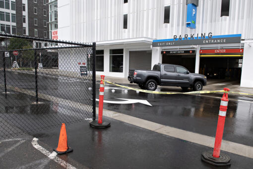 A driver passes a fence and caution tape that prevent entry into a former surface parking lot near the new parking center at The Waterfront Vancouver in September. A new commercial parking tax may dissuade people from visiting the waterfront, said Barry Cain, president of Gramor Development, which owns the new parking garage.