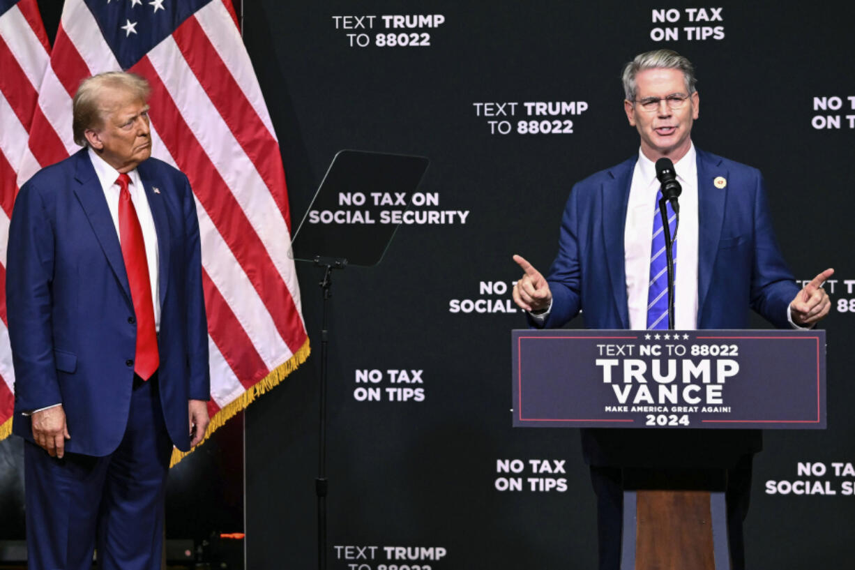 FILE - Republican presidential nominee former President Donald Trump, left, listens as investor Scott Bessent speaks on the economy in Asheville, N.C., Aug. 14, 2024.