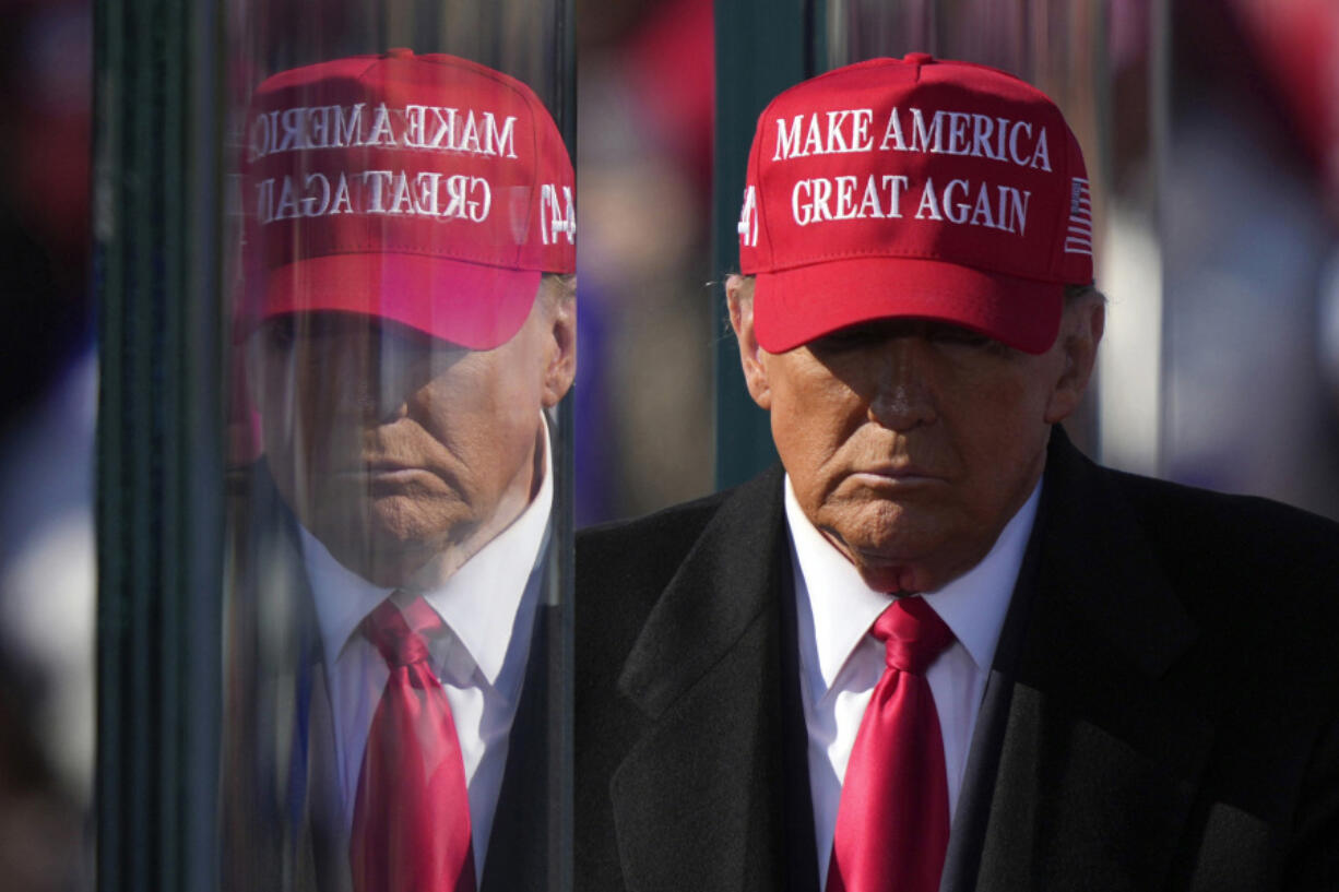 FILE - Republican presidential nominee former President Donald Trump is reflected in the bullet proof glass as he finishes speaking at a campaign rally in Lititz, Pa., Nov. 3, 2024.