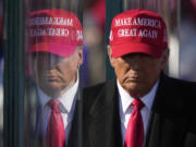 FILE - Republican presidential nominee former President Donald Trump is reflected in the bullet proof glass as he finishes speaking at a campaign rally in Lititz, Pa., Nov. 3, 2024.