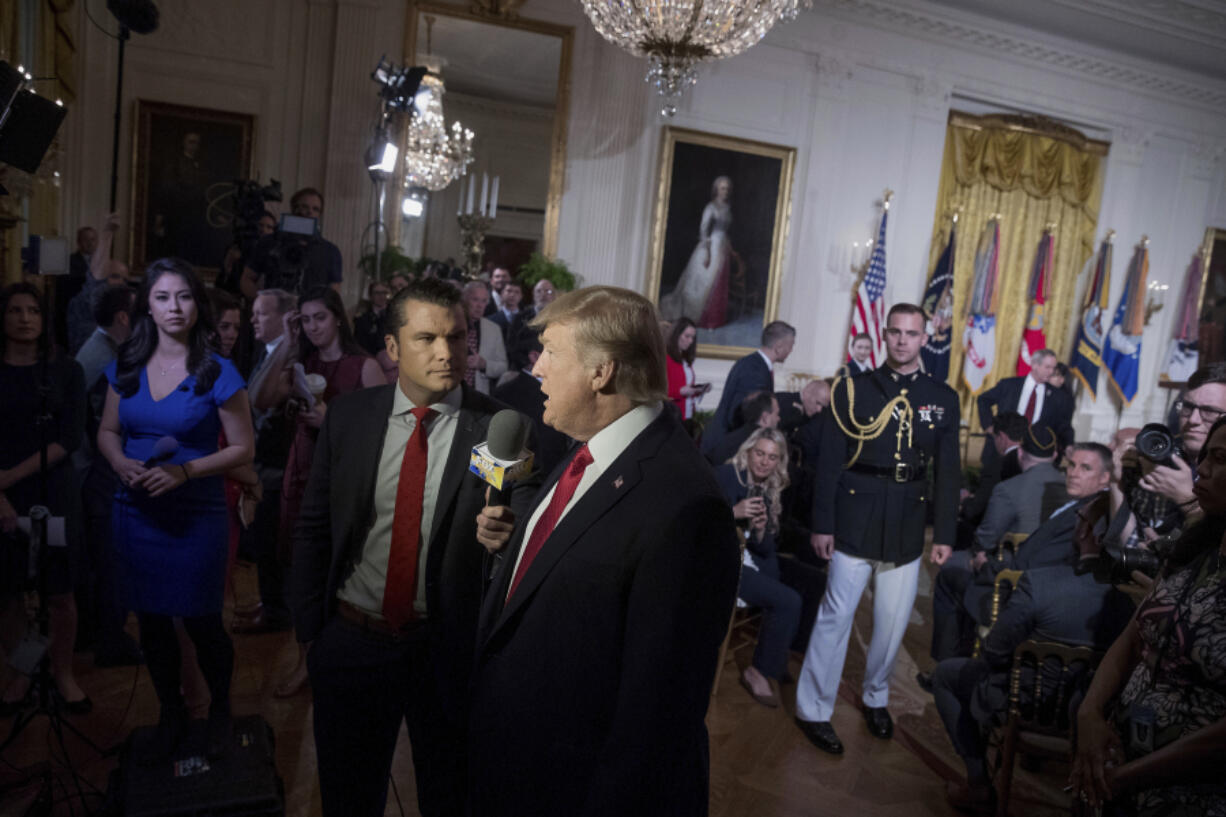 FILE - President Donald Trump appears on Fox &amp; Friends co-host Pete Hegseth at a Wounded Warrior Project Soldier Ride event in the East Room of the White House in Washington, Thursday, April 6, 2017.