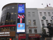 A pedestrian passes a digital screen showing news headlines about the U.S. election, in Leicester Square, London, Wednesday, Nov. 6, 2024.