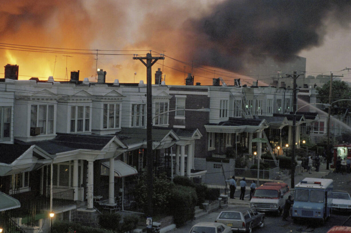 FILE - In May of 1985, scores of row houses burn in a fire in the West Philadelphia neighborhood. Police dropped a bomb on the militant group MOVE&rsquo;s home, May 13, 1985, in an attempt to arrest members, leading to the burning of scores of homes in the neighborhood.