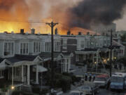 FILE - In May of 1985, scores of row houses burn in a fire in the West Philadelphia neighborhood. Police dropped a bomb on the militant group MOVE&rsquo;s home, May 13, 1985, in an attempt to arrest members, leading to the burning of scores of homes in the neighborhood.