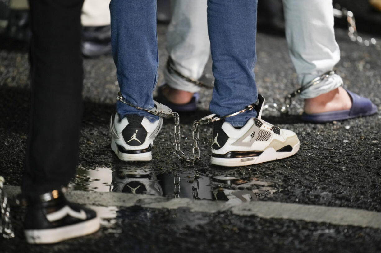 FILE - Shackled Ecuadorian migrants line up to board a plane for deportation from the Albrook airport in Panama City, Aug. 29, 2024.