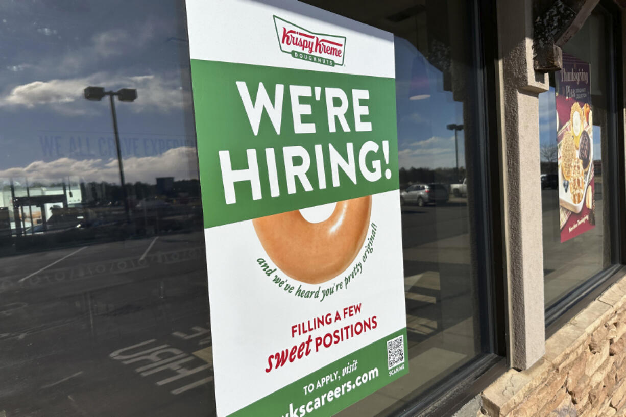 FILE - A hiring sign is displayed in the window of a Krispy Kreme donut shop on Nov. 19, 2024, in Lone Tree, Colo.