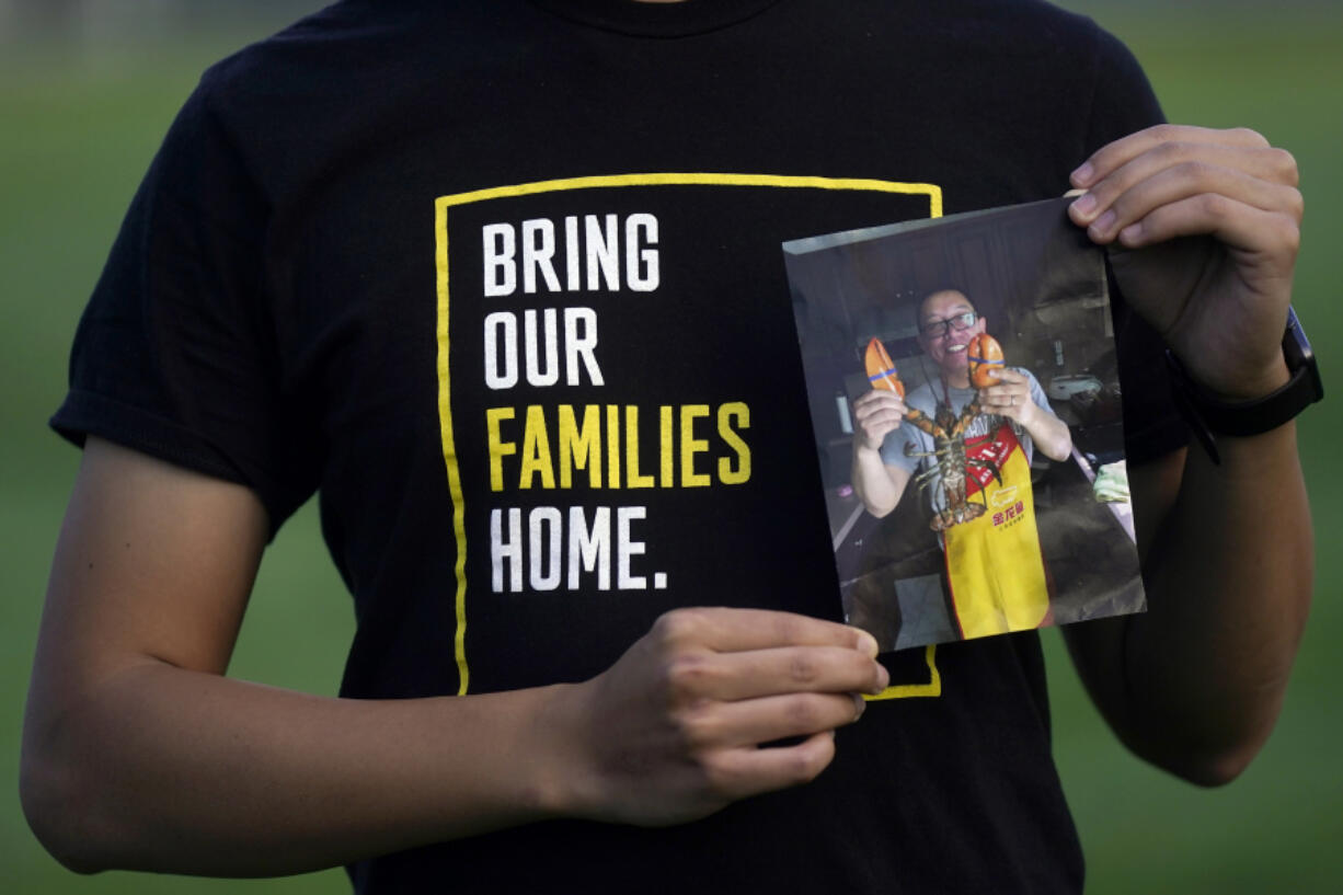 FILE - Harrison Li holds a photo of his father, Kai Li, as he poses for a photo, Tuesday, Jan. 23, 2024, in Palo Alto, Calif.