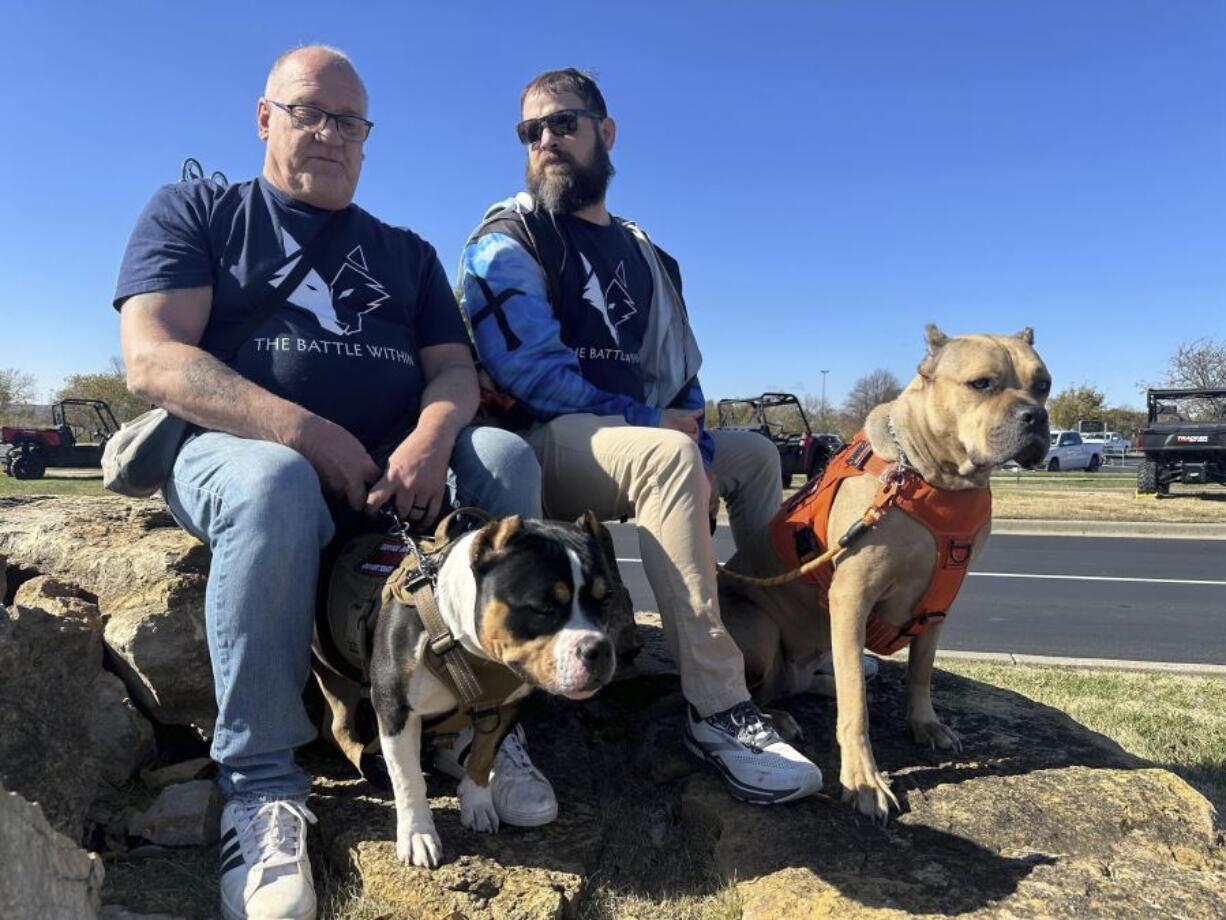 Retired Army First Sgt. Timothy Siebenmorgen, left, and retired Marine Corps Cpl. Mark Atkinson sit Nov. 7 with their service dogs, Rosie and Lexi in Kansas City, Kan., during a group training session.