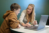 Third-grader Logan Kitchens, left, works with teacher Brooke Mason on Monday morning while using the MagicSchool AI program at the Washington School for the Deaf.