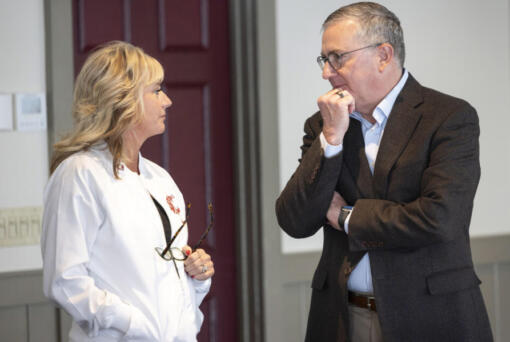 WSU President Kirk Schulz, right, speaks to past board Chair Marty Dickinson during November&rsquo;s Board of Regents meeting in Seattle.