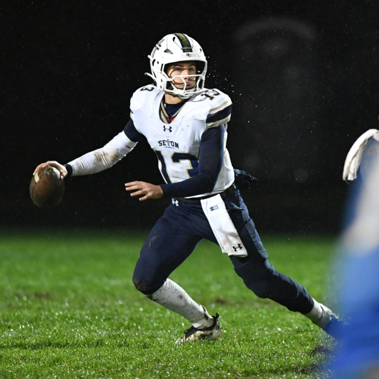 Seton Catholic junior Kolten Gesser (13) looks for an open receiver Friday, Nov. 1, 2024, during Seton Catholic's 29-21 win against La Center at La Center High School. Seton won the 1A Trico League Championship with the victory.