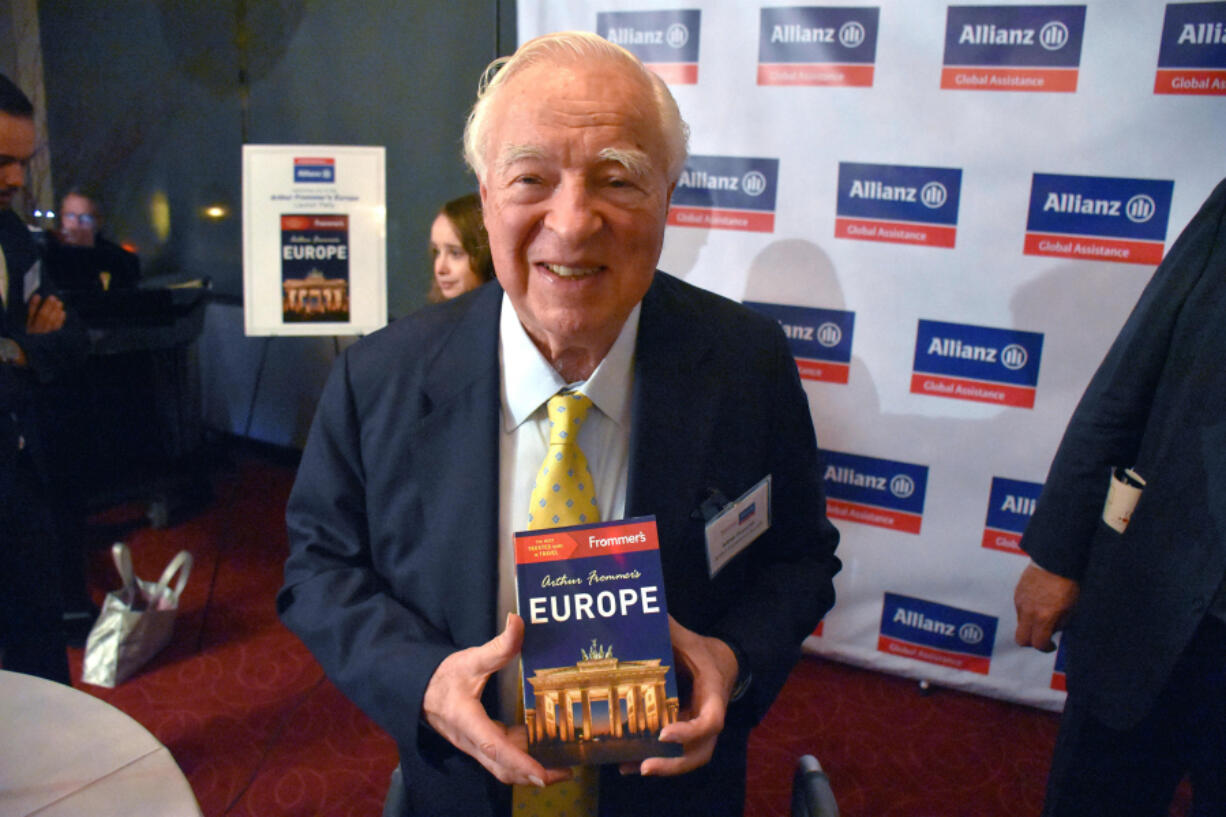 Guidebook author and publisher Arthur Frommer holds up his latest book Nov. 18, 2015, &ldquo;Arthur Frommer&rsquo;s Europe,&rdquo; in New York.