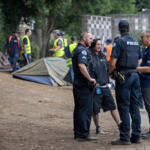 Cleanup crews remove solid waste along the Mill Plain Boulevard sound wall while joined by officials and members of the HART team. The city plans to close the camp around February. (Amanda Cowan/The Columbian files)