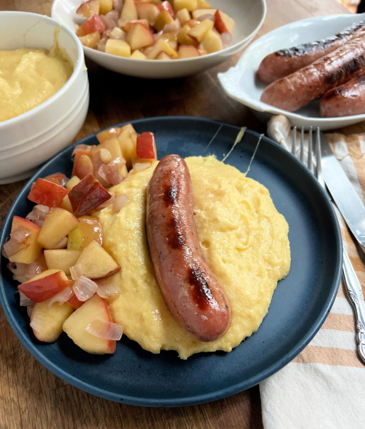 Apple sausage and sauteed apples on a bed of cheesy polenta is a quick midweek autumn meal.