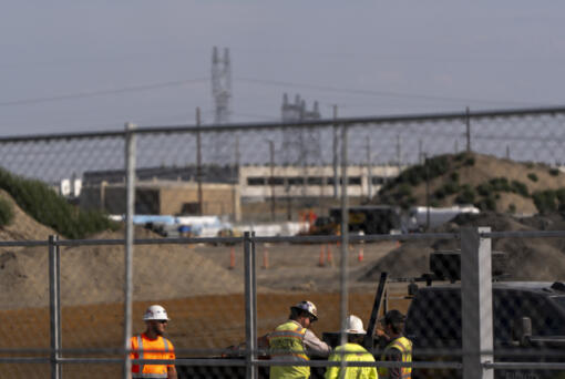 Workers talk outside an Amazon Web Services data center that is under construction on Wednesday, Aug. 21, 2024, in Boardman, Ore.