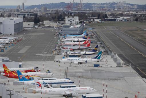 FILE - This Feb. 23, 2018 file photo shows cranes from the Port of Seattle in the background, airplanes are parked at a Boeing facility at Boeing Field in Seattle. (AP Photo/Ted S.