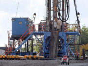 FILE - A crew works on a gas drilling rig at a well site for shale based natural gas in Zelienople, Pa. June 25, 2012.