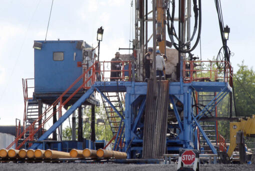 FILE - A crew works on a gas drilling rig at a well site for shale based natural gas in Zelienople, Pa. June 25, 2012.