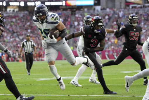 Seattle Seahawks running back Zach Charbonnet (26) scores a touchdown against the Arizona Cardinals during the first half of an NFL football game, Sunday, Dec. 8, 2024, in Glendale, Ariz.