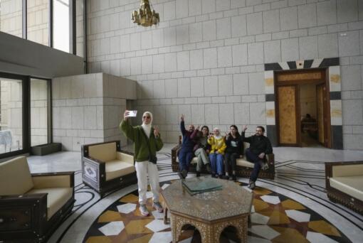 People pose for a photo Sunday in Syrian President Bashar Assad&rsquo;s palace in Damascus.