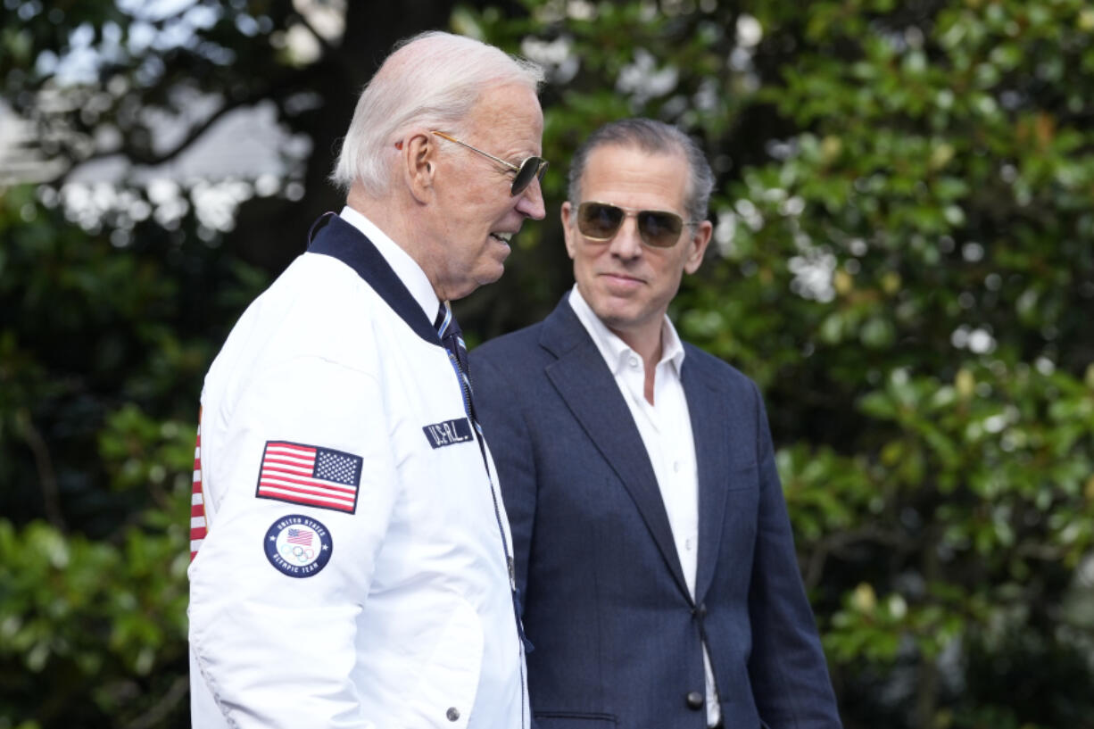 President Joe Biden, wearing a Team USA jacket and walking with his son Hunter Biden, heads toward Marine One on the South Lawn of the White House in Washington, July 26, 2024.