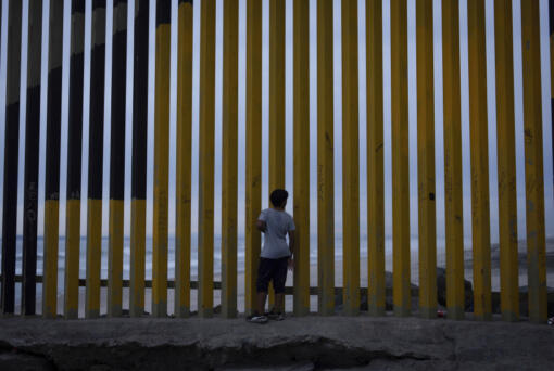 FILE - A boy looks through a border wall separating Mexico from the United States, Nov. 26, 2024, in Tijuana, Mexico.