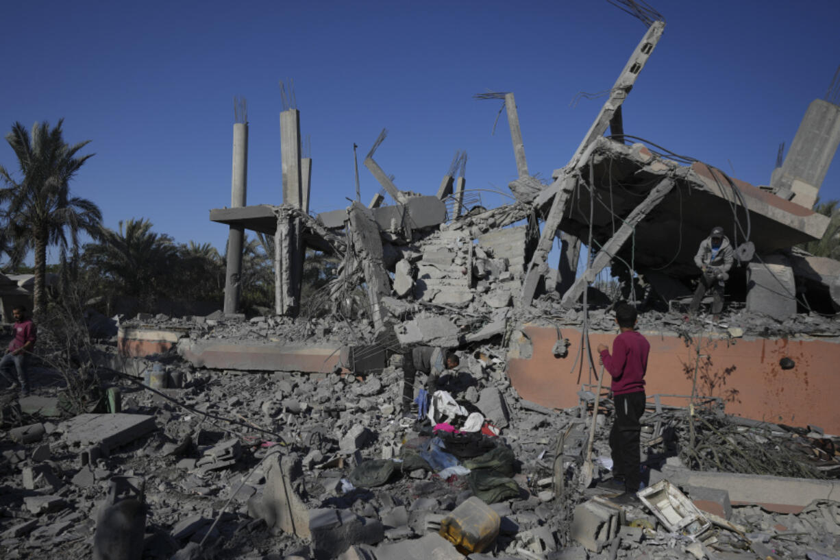 Palestinians check the rubble of a destroyed building following an overnight Israeli strike in Deir al-Balah, Gaza Strip, Wednesday, Dec. 4, 2024.