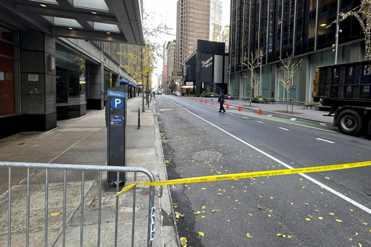 A New York police officer walks outside a hotel where a 50-year-old man was fatally shot in midtown Manhattan, Wednesday, Dec. 4, 2024, in New York.