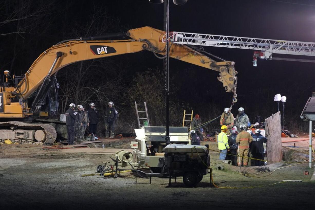 Rescue workers search through the night in a sinkhole for Elizabeth Pollard, who disappeared while looking for her cat, in Marguerite, Pa., Tuesday, Dec. 3, 2024. (AP Photo/Gene J.