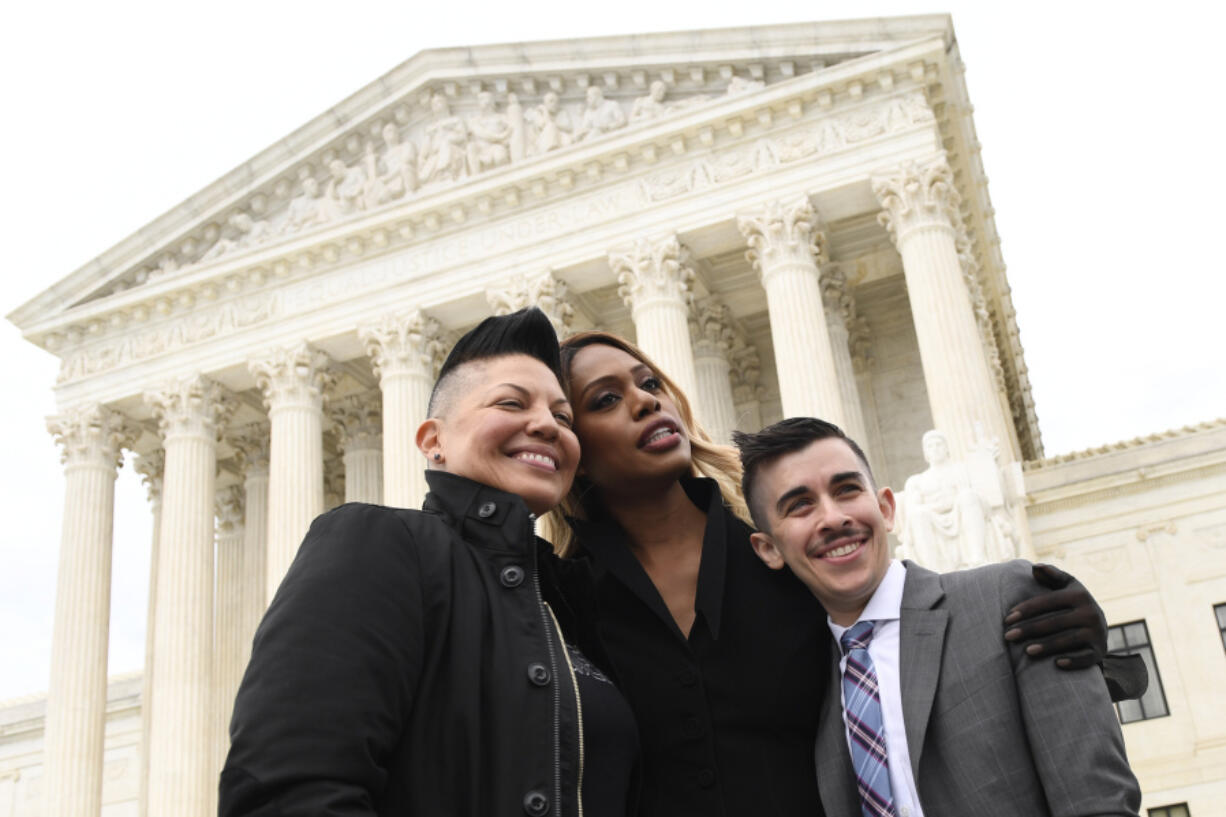 FILE - Sara Ramirez, from left, Laverne Cox and Chase Strangio, an attorney with the American Civil Liberties Union, pose for a photo outside the Supreme Court in Washington, Oct. 8, 2019.