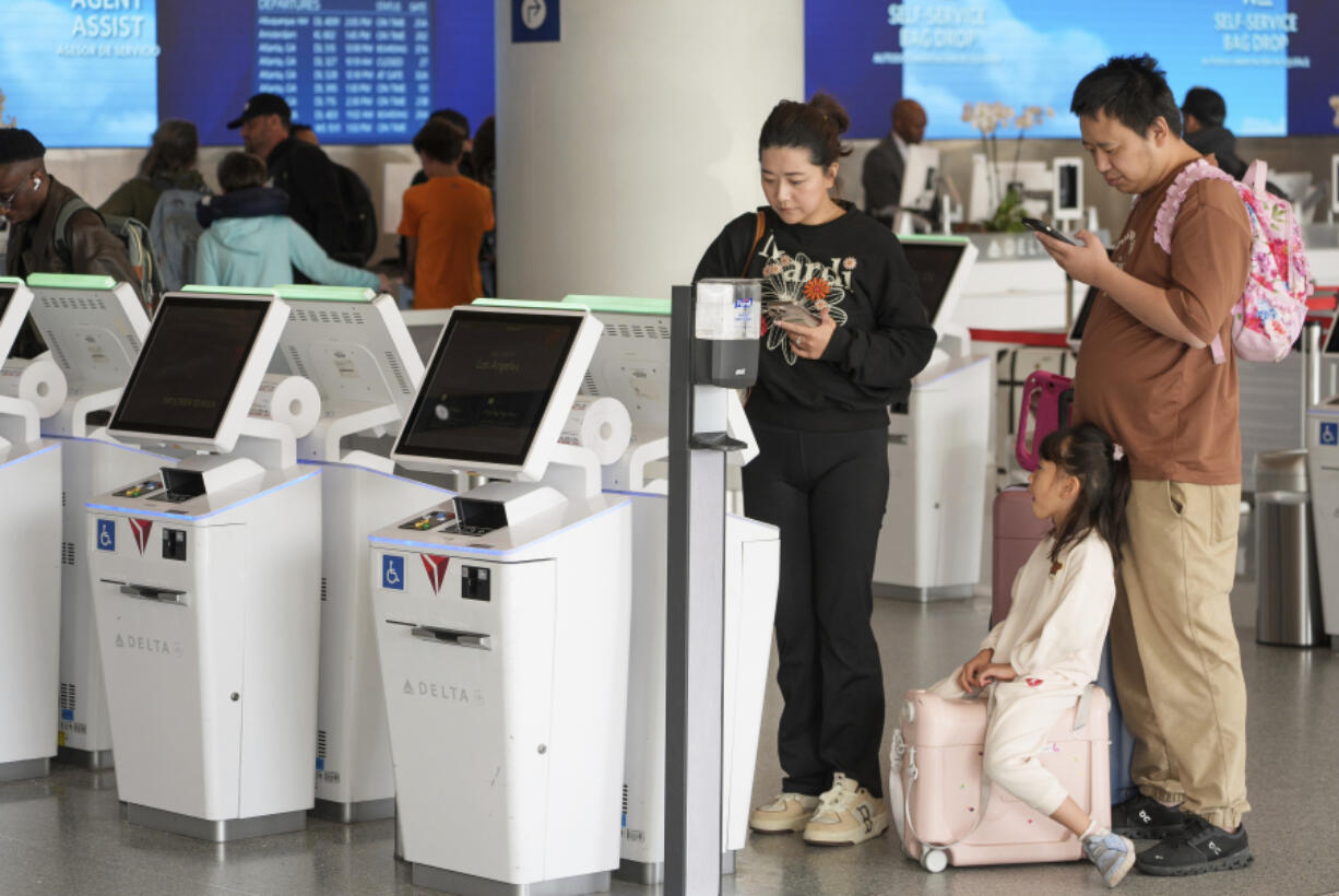 Travelers self-check at Delta Airlines counter at Los Angeles International Airport in Los Angeles, Wednesday, Nov. 27, 2024.