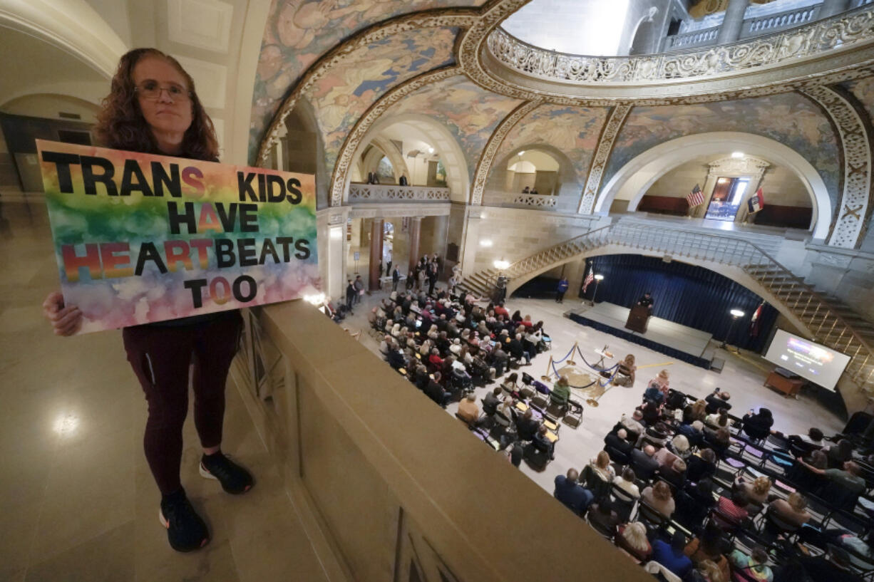 FILE - Julia Williams holds a sign in counterprotest during a rally in favor of a ban on gender-affirming health care legislation, Monday, March 20, 2023, at the Missouri Statehouse in Jefferson City, Mo.