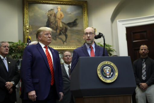 FILE - President Donald Trump, left, listens as acting director of the Office of Management and Budget Russel Vought speaks during an event on &ldquo;transparency in Federal guidance and enforcement&rdquo; in the Roosevelt Room of the White House, Oct. 9, 2019, in Washington.