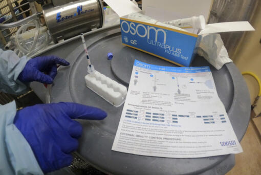 FILE - In this image provided by the U.S. Department of Agriculture, a researcher performs a rapid antigen test on milk from a dairy cow inoculated against bird flu in a containment building at the National Animal Disease Center research facility in Ames, Iowa, on Monday, July 29, 2024.