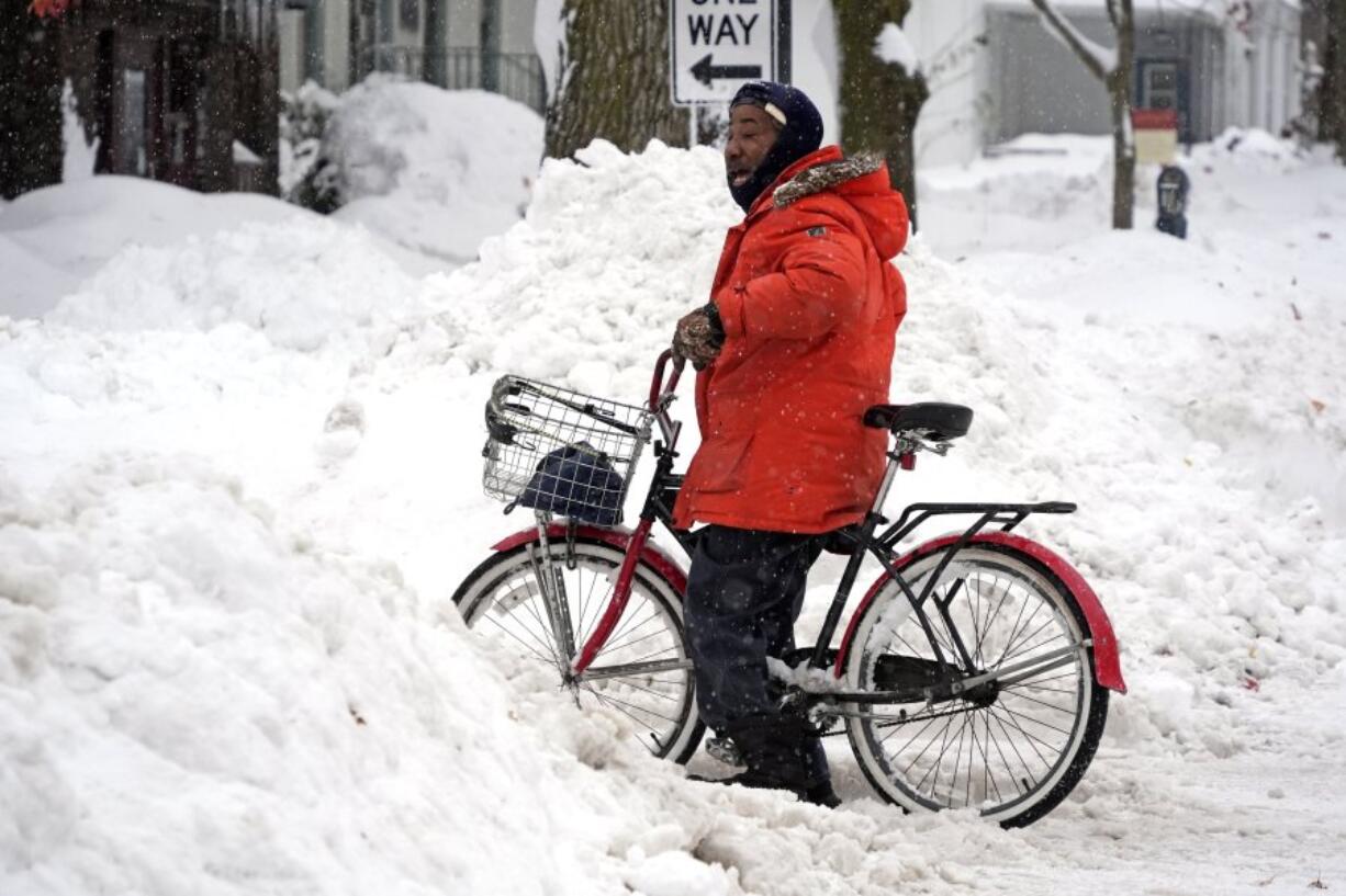 Terrence Yarbrough of Erie, Pa, takes a break from riding his bicycle through the streets of downtown Erie, Pa, Monday, Dec. 2, 2024. (AP Photo/Gene J.