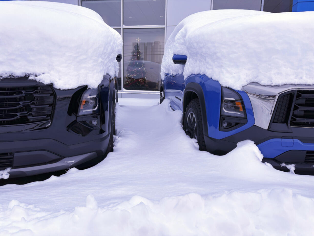 Vehicles are covered during a snow storm in Lowville, N.Y., on Sunday Dec, 1, 2024.